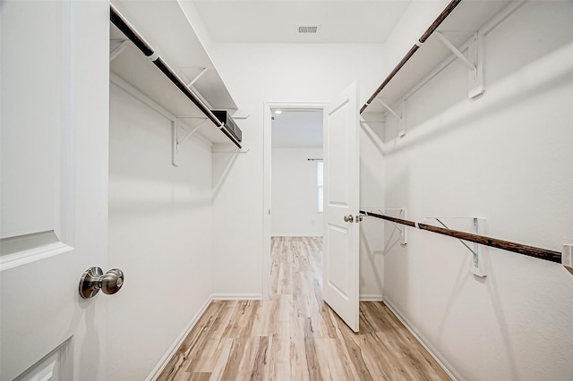 spacious closet with light hardwood / wood-style flooring