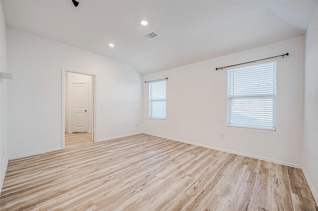 unfurnished room featuring plenty of natural light, light hardwood / wood-style floors, and lofted ceiling