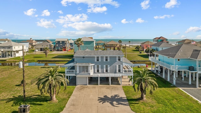 exterior space featuring a carport, a balcony, a water view, and a garage