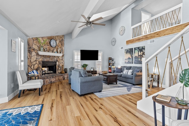 living room with a fireplace, vaulted ceiling with beams, hardwood / wood-style flooring, and ceiling fan