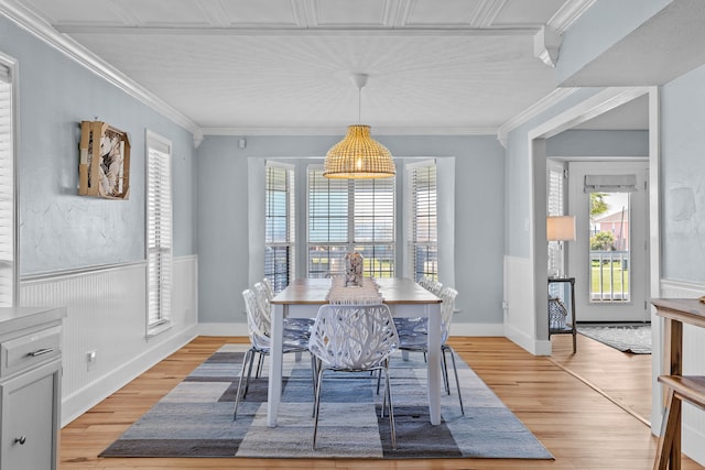 dining space with light wood-type flooring and crown molding