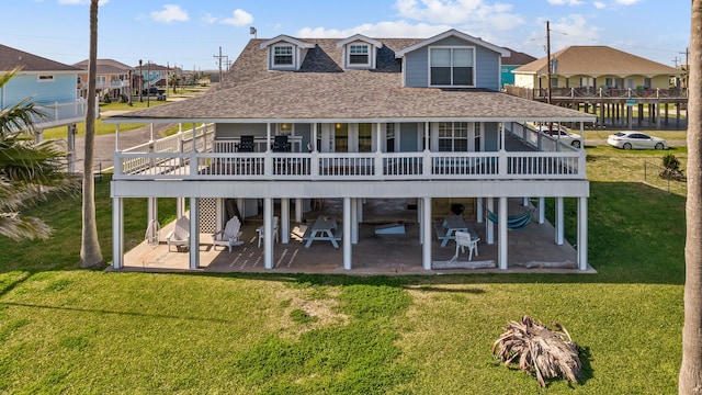 rear view of property featuring a wooden deck, a yard, and a patio area