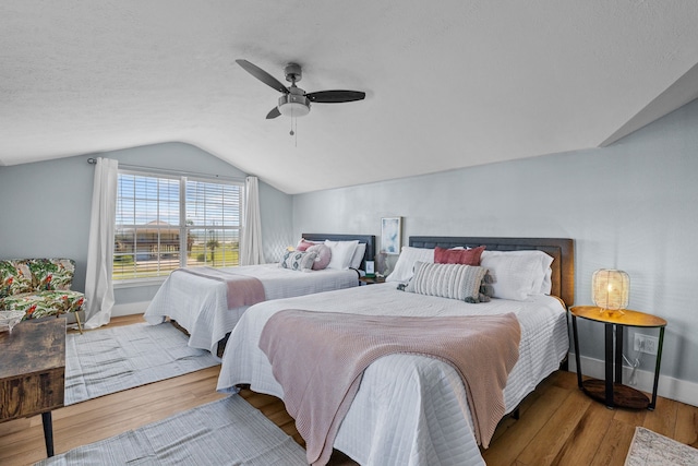 bedroom with ceiling fan, light hardwood / wood-style flooring, and lofted ceiling