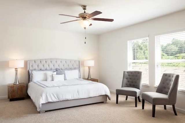 bedroom featuring multiple windows, ceiling fan, and light carpet