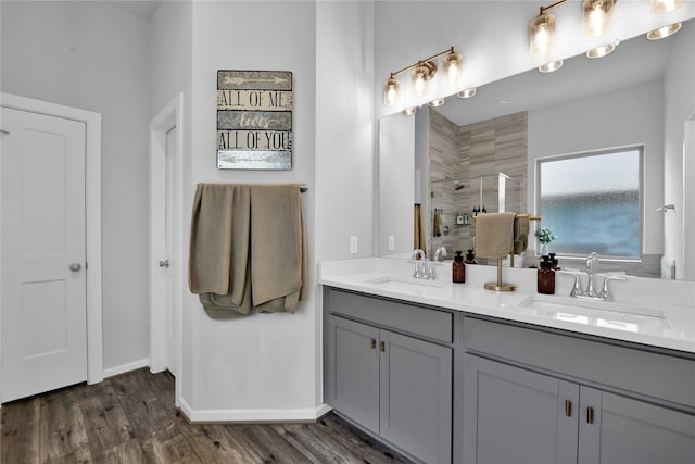 bathroom with hardwood / wood-style floors, vanity, and a shower with door