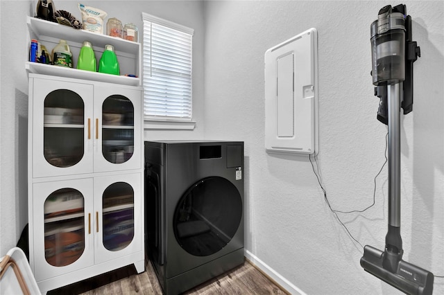 laundry room with dark hardwood / wood-style flooring and electric panel