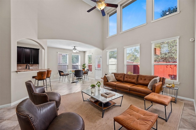 living room featuring sink, a healthy amount of sunlight, light tile patterned floors, and ceiling fan