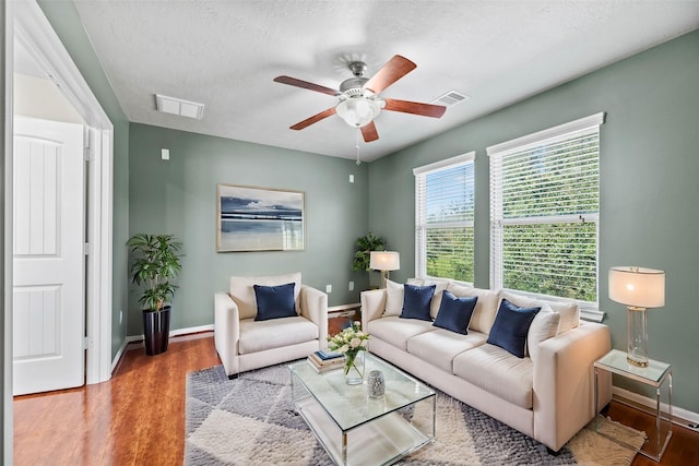 living room featuring a textured ceiling, light hardwood / wood-style floors, and ceiling fan