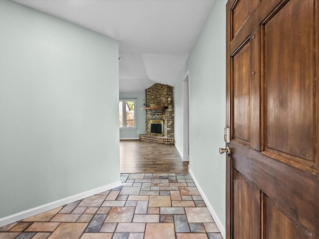 entryway with a fireplace and vaulted ceiling