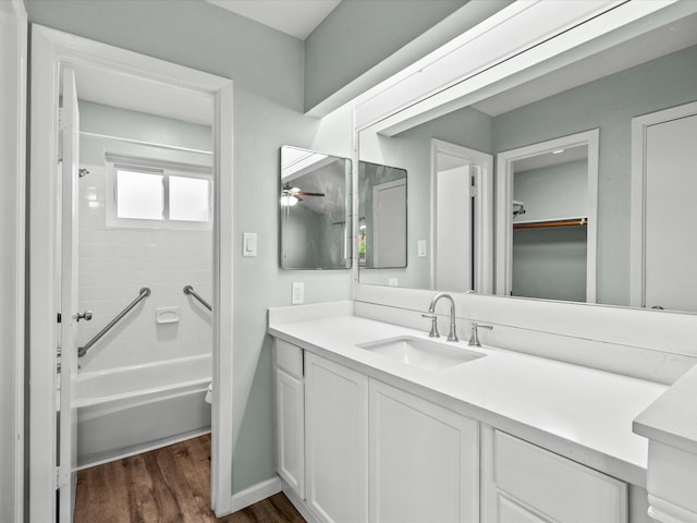 bathroom with shower / tub combination, vanity, hardwood / wood-style flooring, and ceiling fan