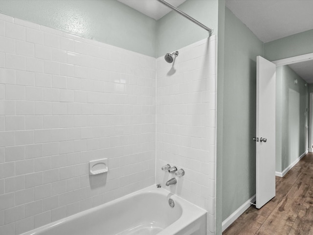 bathroom featuring bathing tub / shower combination and hardwood / wood-style flooring