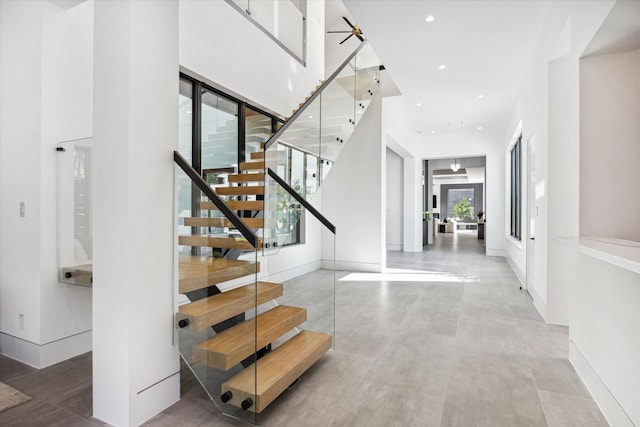 staircase featuring ceiling fan