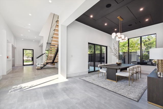 interior space with a wealth of natural light, a high ceiling, and a notable chandelier