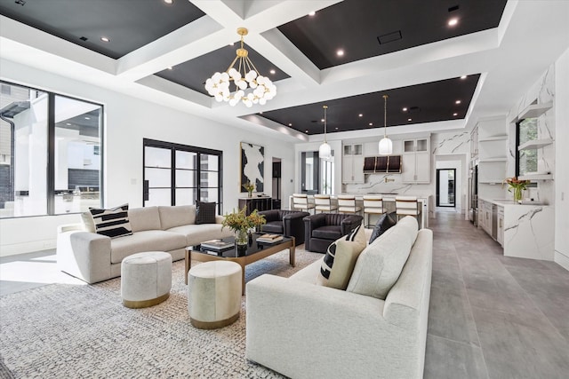 living room with beam ceiling, an inviting chandelier, and coffered ceiling