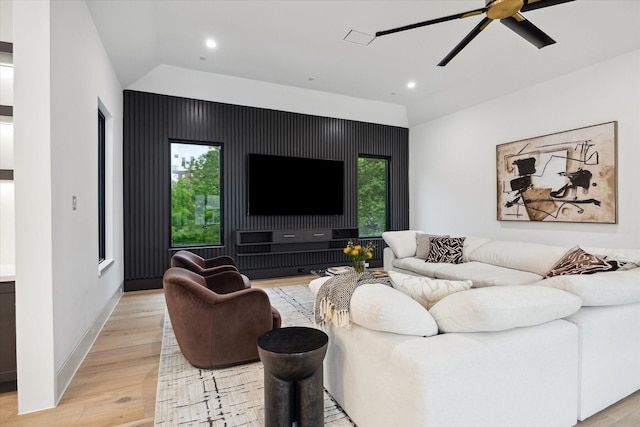 living room with ceiling fan, light hardwood / wood-style floors, a healthy amount of sunlight, and vaulted ceiling