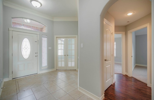 foyer entrance with light tile patterned floors, french doors, and crown molding