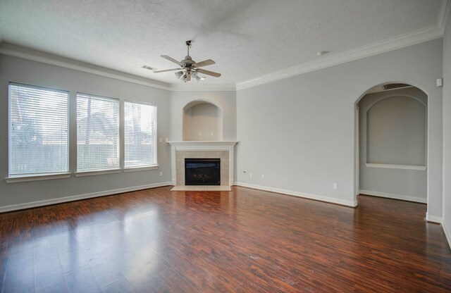 unfurnished living room featuring a textured ceiling, ceiling fan, ornamental molding, and a tiled fireplace