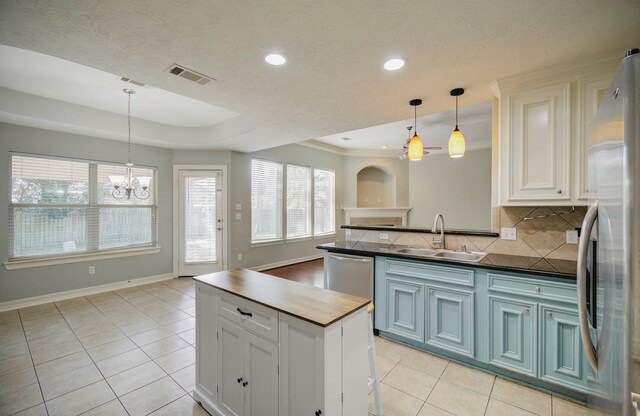 kitchen with white cabinets, sink, appliances with stainless steel finishes, and a chandelier