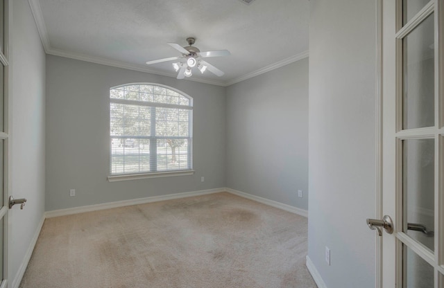 carpeted spare room with ceiling fan and ornamental molding