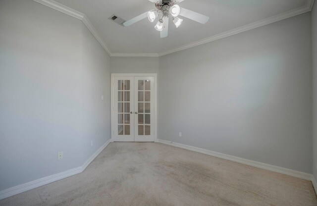 spare room with crown molding, ceiling fan, french doors, and light colored carpet