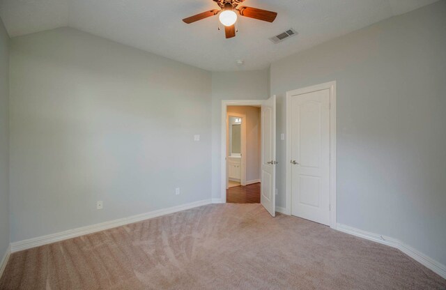 unfurnished room featuring ceiling fan, light colored carpet, and vaulted ceiling