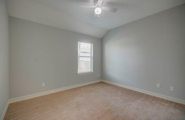 carpeted spare room featuring ceiling fan and lofted ceiling