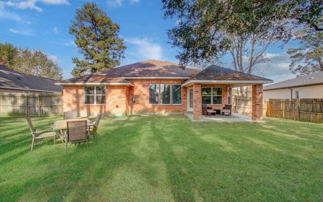 rear view of house featuring a lawn and a patio area