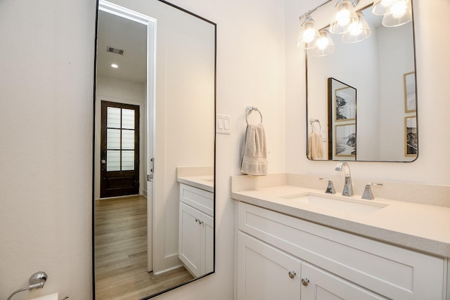 bathroom with a chandelier, wood-type flooring, and vanity