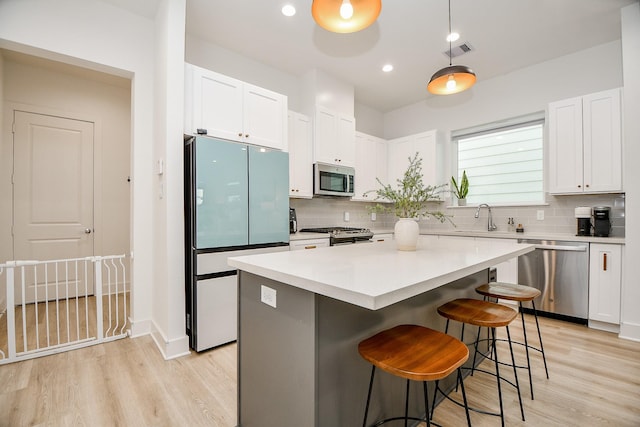 kitchen featuring white cabinets, stainless steel appliances, and a kitchen island