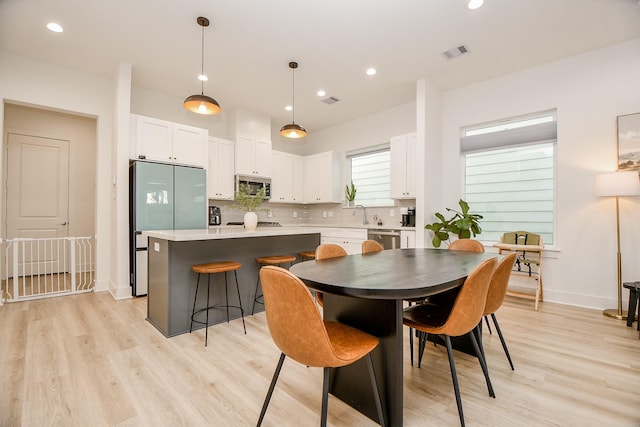 dining space with sink and light hardwood / wood-style flooring