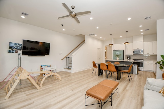 living room with ceiling fan and light hardwood / wood-style floors