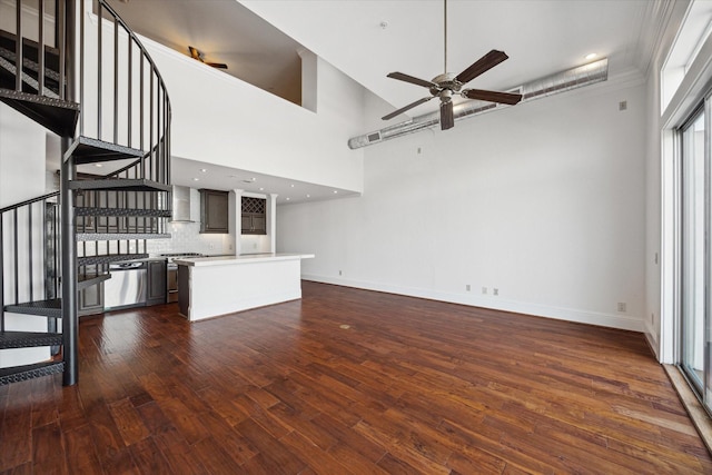 2510 Travis St Unit 303, Houston, TX 77006 - unfurnished living room featuring a ceiling fan, stairway, dark wood-style floors, and a towering ceiling