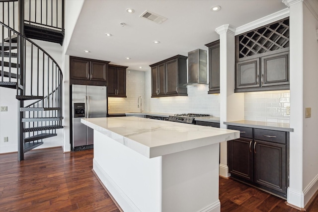 kitchen featuring dark hardwood / wood-style flooring, sink, wall chimney range hood, stainless steel fridge with ice dispenser, and a center island