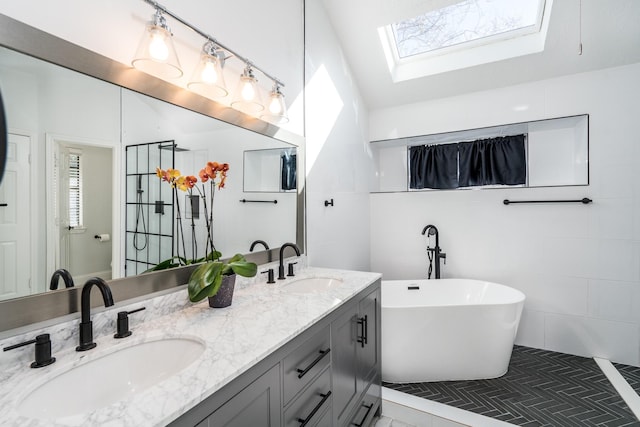 bathroom with vanity, a tub to relax in, plenty of natural light, and a skylight