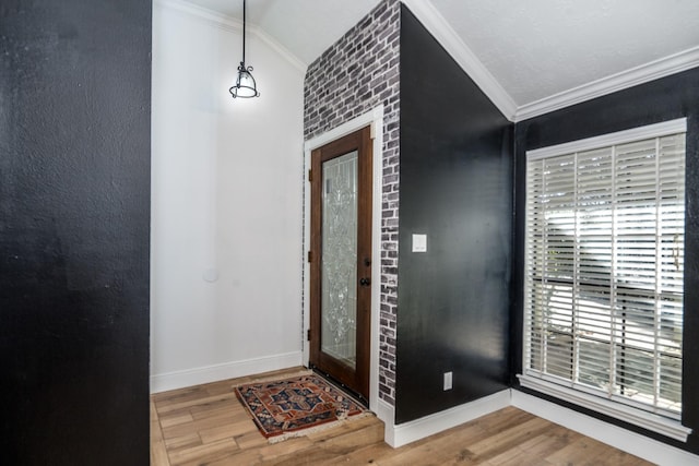 entrance foyer featuring lofted ceiling, ornamental molding, and wood-type flooring