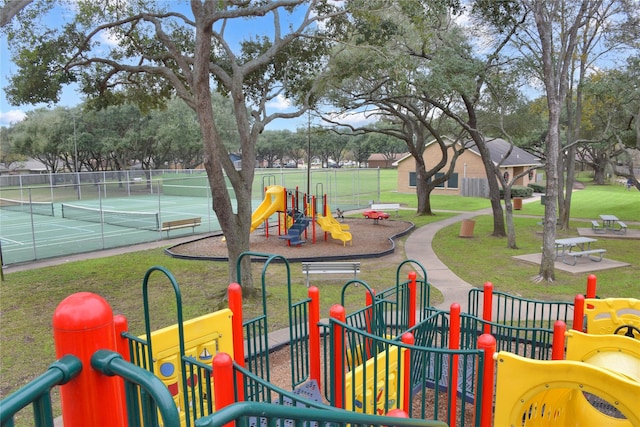 view of jungle gym with tennis court and a lawn