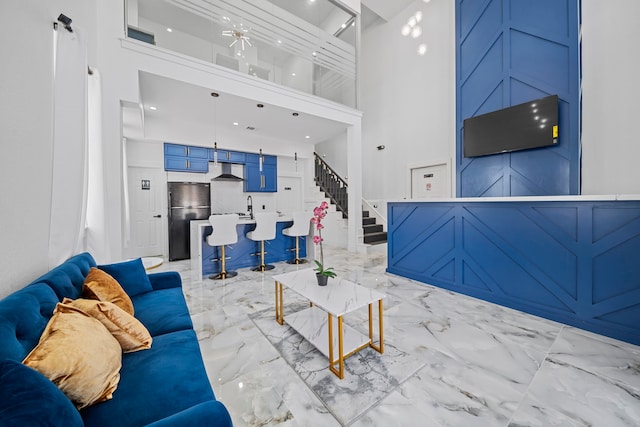 living room featuring a towering ceiling and sink