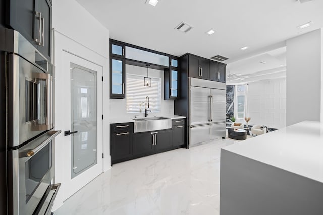 kitchen featuring refrigerator, decorative light fixtures, built in fridge, and sink