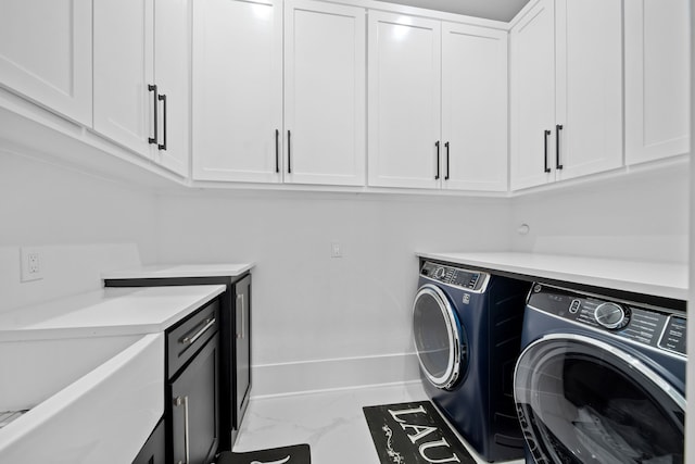 clothes washing area featuring washer and dryer and cabinets