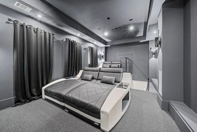 bedroom with carpet flooring and a raised ceiling