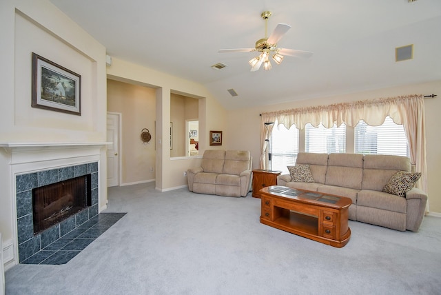 living room with a tile fireplace, carpet floors, vaulted ceiling, and ceiling fan