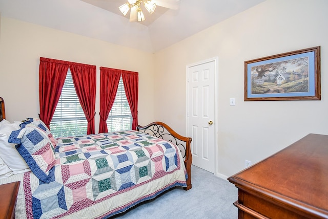 carpeted bedroom with ceiling fan and vaulted ceiling