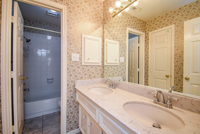 full bathroom featuring tiled shower / bath combo, vanity, toilet, and tile patterned flooring