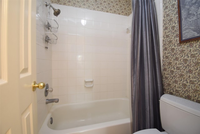 bathroom featuring toilet and shower / bath combination with curtain