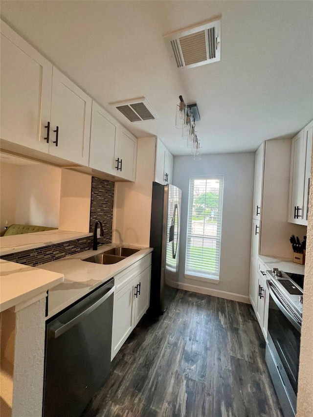 kitchen with white cabinetry, backsplash, and appliances with stainless steel finishes