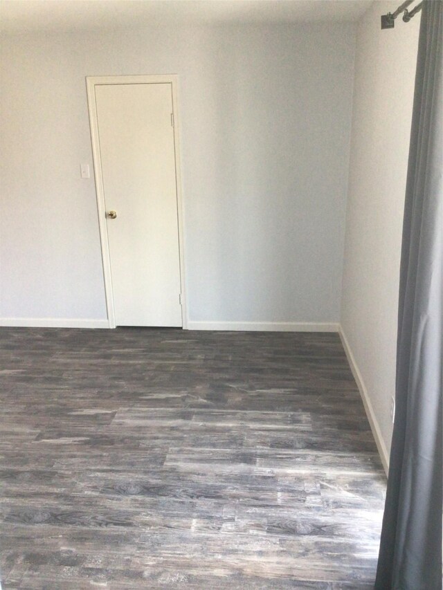 spare room featuring dark wood-type flooring