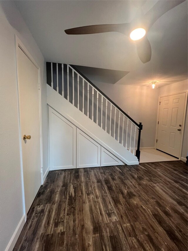 staircase with wood-type flooring and ceiling fan