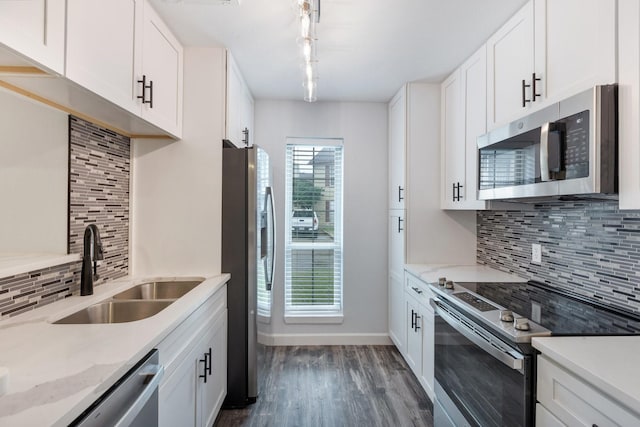 kitchen with stainless steel appliances, a sink, dark wood-type flooring, and tasteful backsplash
