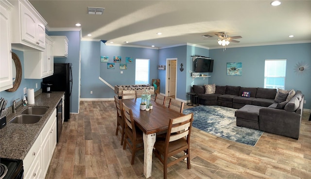 dining room with light hardwood / wood-style floors, ceiling fan, ornamental molding, and sink