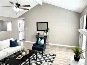 living room with vaulted ceiling with beams, light hardwood / wood-style floors, a wealth of natural light, and ceiling fan